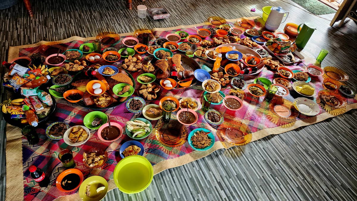 A variety of dishes and snacks are laid out on a colorful pandan mat inside a home in the barangay of Laud. Everyone is invited to partake of the feast.